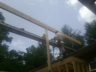 Carpenter setting a ridge beam over a new addition frame — Ice Dam Removal by Roofing Brothers in Monmouth Junction