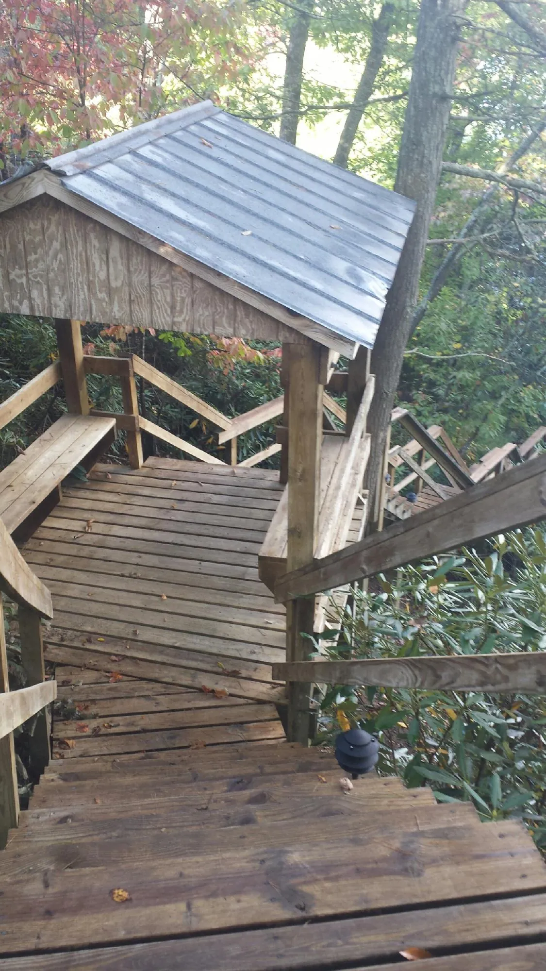 Metal roofed shelter over wooden steps on a wooded walkway — Skylight Repair & Installation work by our crew in Monmouth Junction