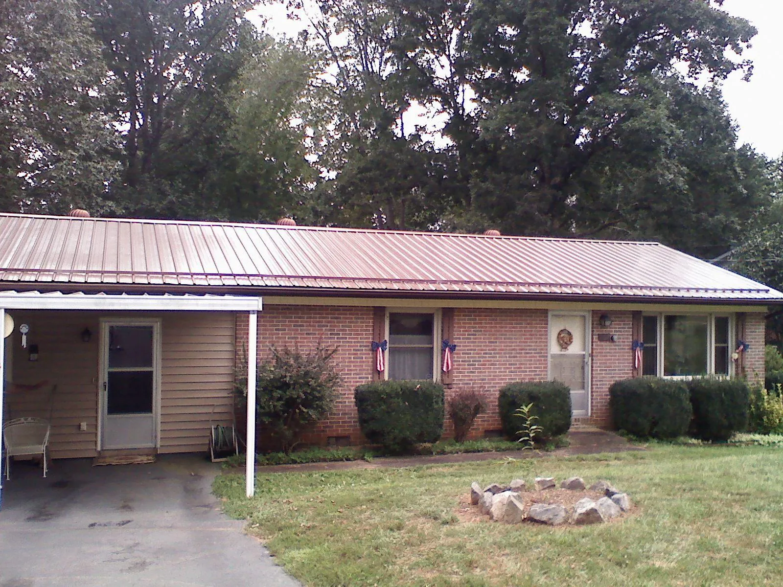 Bronze metal roof and carport on a brick ranch home — Roof Repair work by our crew in Monmouth Junction